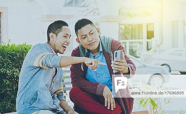 Mann zeigt sein Handy einem anderen Mann  zwei Freunde prüfen ihre Handys  zwei junge Freunde haben eine gute Zeit
