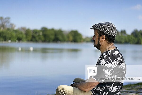Porträt eines Mannes  der entspannt sitzt und über einen See nachdenkt. Leerzeichen kopieren