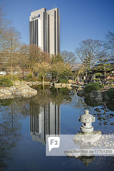 Blick vom japanischen Garten in Planten un Blomen auf das Radisson-Hotel am Hamburger Dammtor. Das Hochhaus-Fassade spiegelt sich im Teich