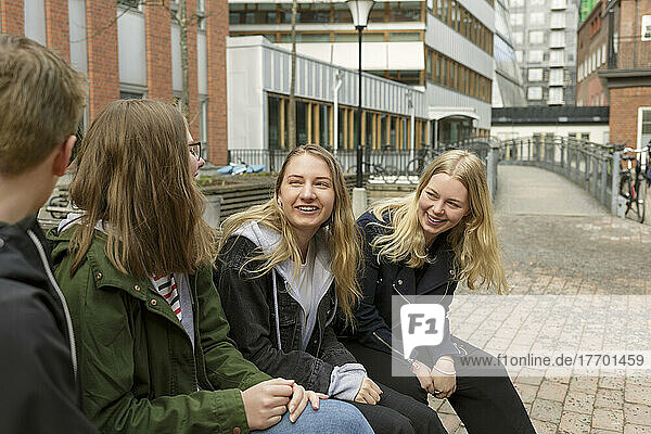 Friends sitting on bench in Stockholm  Sweden