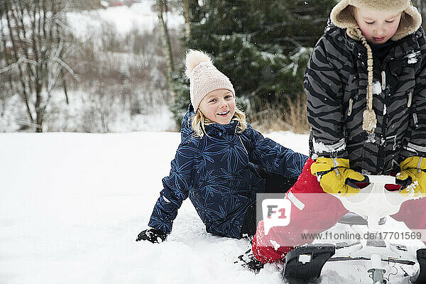 Girls playing with toboggan at ski field