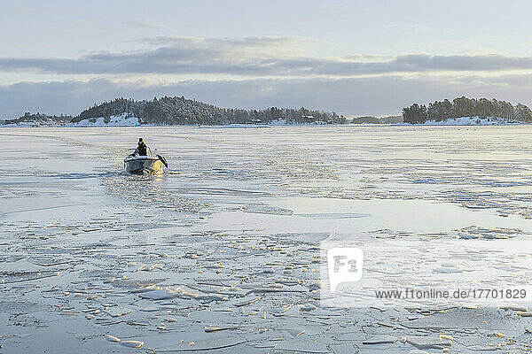 Man in boat on frozen sea