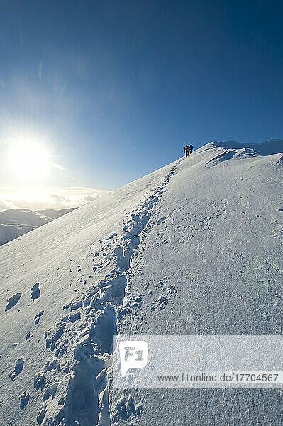 Fußspuren von Wanderern  die den verschneiten Bergrücken von Sgorr Dhearg im Winter in der Nähe von Glen Coe erklimmen; Highlands  Schottland