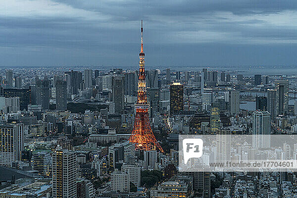 The Tokyo Tower illuminated at dusk under an overcast sky. Tokyo Tower is a communications and observation tower in the Shiba-koen district of Minato  Tokyo  Japan  built in 1958. At 332.9 meters (1 092 ft)  it is the second-tallest structure in Japan. The structure is an Eiffel Tower-inspired lattice tower that is painted white and international orange to comply with air safety regulations; Tokyo  Japan
