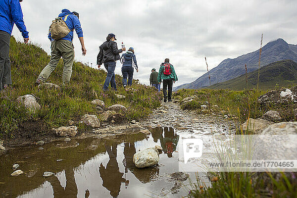 Hikers walk along a creek through the Cuillin Mountains on Isle of Skye  Scotland; Sligachan  Isle of Skye  Scotland