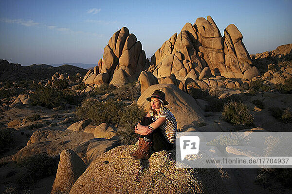 A Young Woman Watches The Sunset In Joshua Tree National Park; California  United States Of America