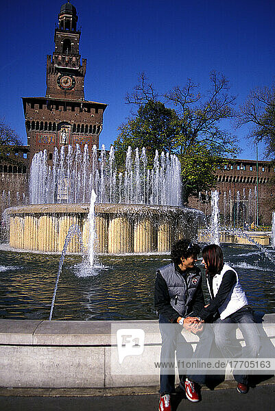 Junges Paar sitzt neben einem Brunnen am Castello Sforzesco  hält Händchen  Liebe  Romantik. Mailand  Italien