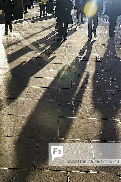 Schatten von Fußgängern auf dem Bürgersteig; London  England