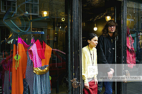 Ein junger Mann und eine junge Frau in der Tür eines Bekleidungsgeschäfts  Brick Lane; London  England