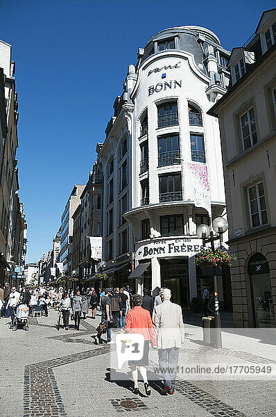 Fußgänger  die eine schmale Straße zwischen Geschäftsgebäuden entlanggehen; Luxemburg