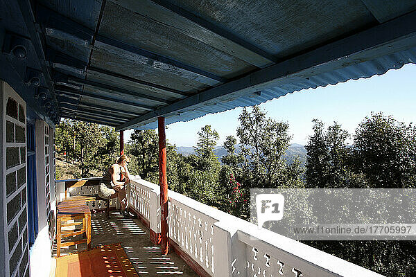 Ein Tourist blickt über das Geländer einer Veranda hinaus auf den indischen Himalaya; Utaranchal  Indien