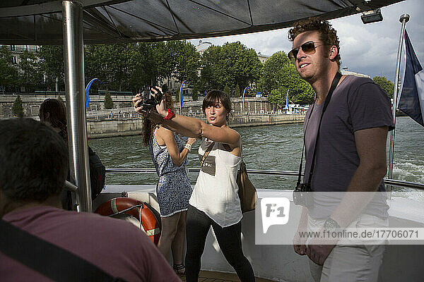 A traveler on a Seine River boat cruise takes a self portrait in Paris  France; Paris  France