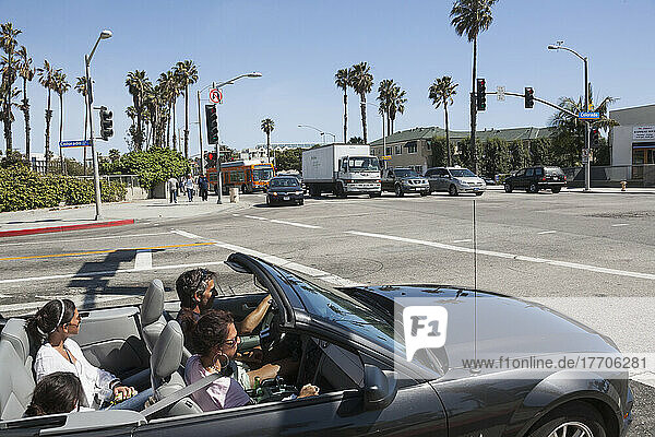 A Family Drives In A Convertible On A Sunny Day; California  United States Of America