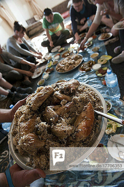 Eine Gruppe von Touristen  die ein traditionelles Mittagessen mit einer einheimischen Familie in der Nähe von Al Ayoun Trail; Jordanien