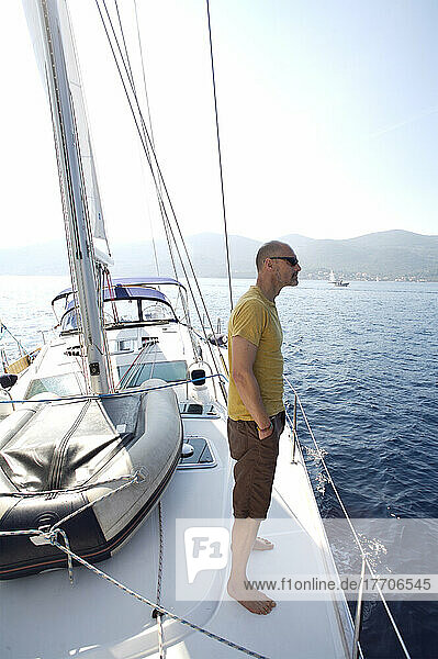 Ein Mann steht auf dem Deck eines Segelbootes; Kroatien