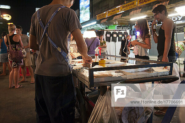Straßenhändler  Einheimische und Touristen mischen sich entlang der Khao San Road bei Nacht; Bangkok  Thailand