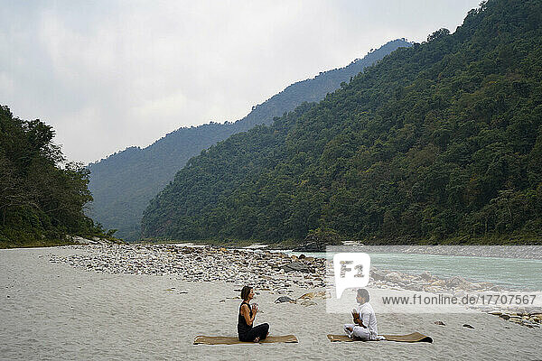 Yogastunde am Ufer des Ganges  der durch die Ausläufer des Himalaya zwischen Rishikesh und Devprayag im Tal des Ganges fließt  Uttarakhand  Indien; Rishikesh  Uttarakhand  Indien