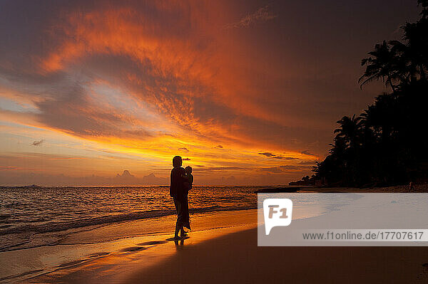 Mutter und Baby beobachten den Sonnenuntergang am Strand  in der Nähe von Unawatuna; Thalpe  Sri Lanka