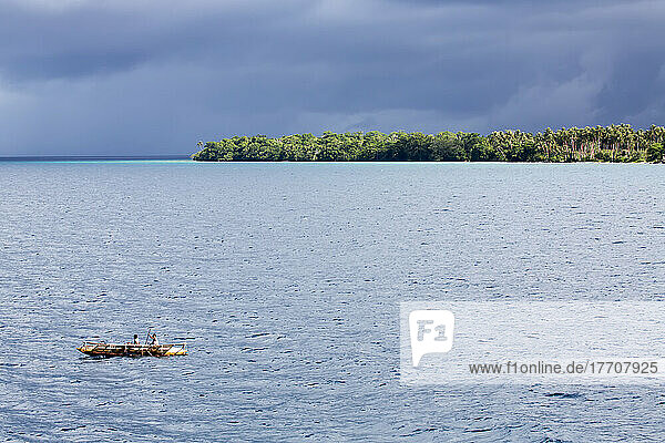 Auslegerkanu unter stürmischem Himmel vor der Küste der Insel Kuiawa auf den Trobriand-Inseln  Papua-Neuguinea; Kuiawa  Provinz Milne Bay  Papua-Neuguinea