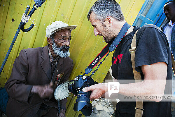 Reisender Fotograf  der einen älteren Mann fotografiert; Äthiopien