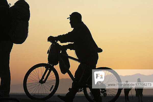 Silhouette Of Cyclists At Sunrise; California  United States Of America