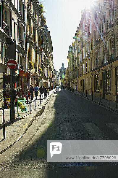 Sonnenlicht auf einem Gehweg mit Fußgängern  Marais-Viertel; Paris  Frankreich