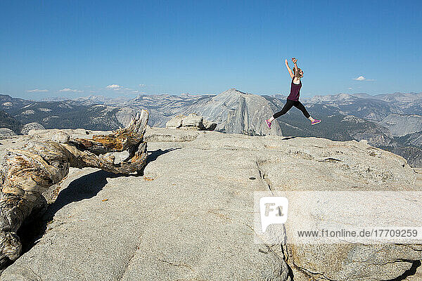 Ein Wanderer springt anmutig in einer Ballettbewegung auf den Sentinel Dome  einen felsigen Gipfel  der einen atemberaubenden Blick auf das Yosemite Valley bietet; Yosemite National Park  Kalifornien