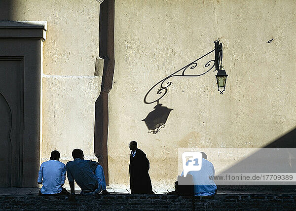 Men Relaxing In Shadow Of Koutoubia Mosque