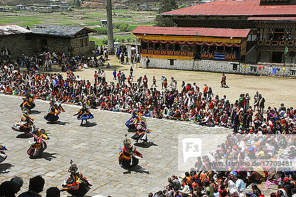 Kostümierte Tänzerinnen und Tänzer führen einen Cham-Tanz beim bhutanischen Paro Tshechu Festival im Paro Dzong  einem Kloster und einer Festung in Paro  Bhutan  auf; Paro  Bhutan