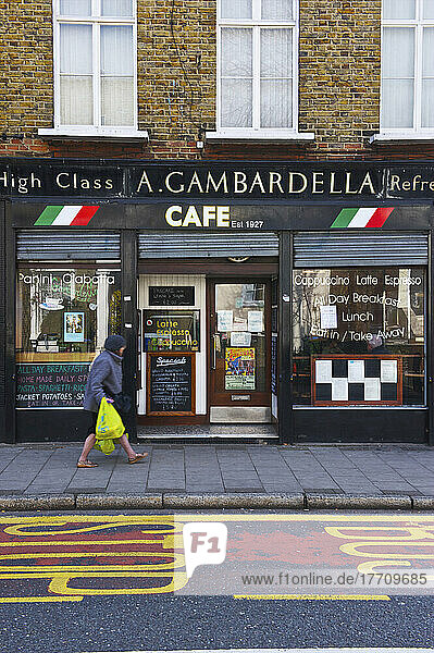 Ein Fußgänger spaziert durch ein Café; London  England
