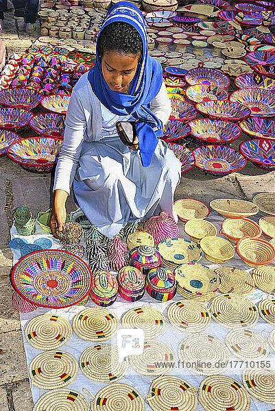 Frau  die auf einem Markt äthiopisches Kunsthandwerk einkauft  mit einer auf dem Boden ausgelegten Auslage; Addis Abeba  Äthiopien