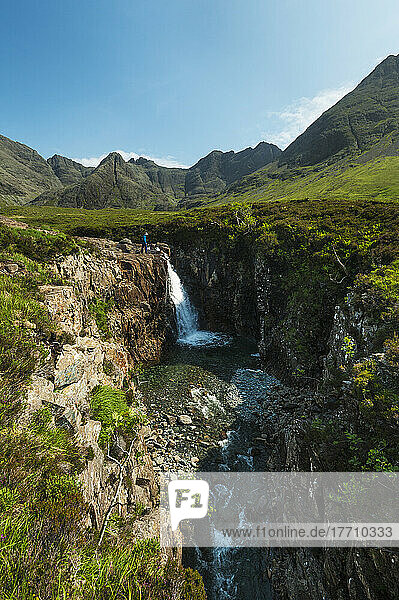 Mann betrachtet kleinen Wasserfall und einen der Fairy Pools in Coire Na Creiche  Black Cuillin; Isle Of Skye  Schottland