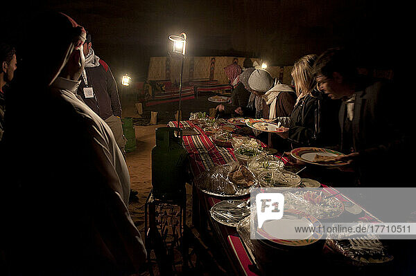 Traditionelles Zarb-Beduinen-Abendessen für Touristen in einem Beduinenlager von Captain's Camp  das Übernachtungsmöglichkeiten in der Wüste anbietet; Wadi Rum  Jordanien