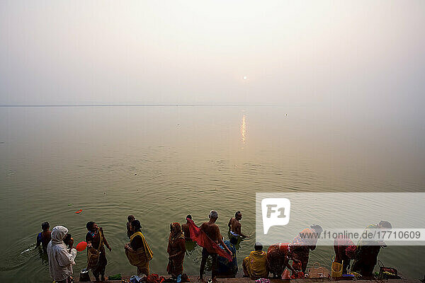 Badende in der Morgendämmerung an den Ghats des Ganges; Varanasi  Indien