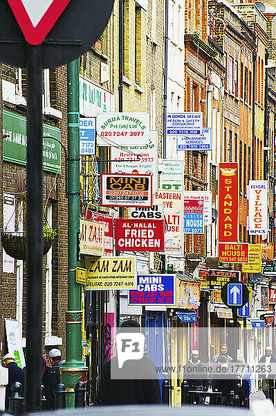 Eine Fülle von Schildern an den Seiten von Gebäuden in der Brick Lane; London  England