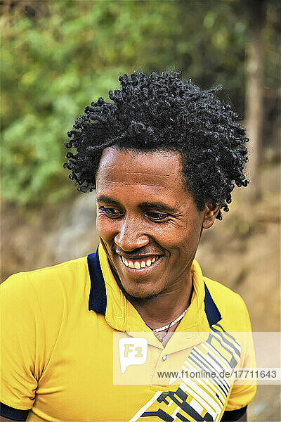 Portrait of a young man with a big smile in rural Ethiopia; Ethiopia