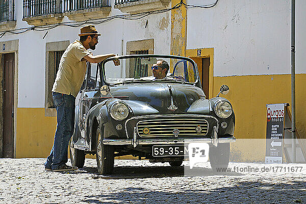 Männer unterhalten sich in einem Oldtimer auf den Straßen von Portugal; Portugal