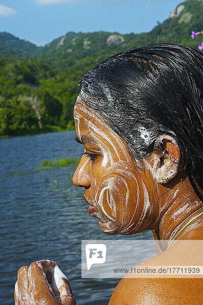 Eine junge Frau wäscht ihr Gesicht in einem Fluss; Ulpotha  Embogama  Sri Lanka