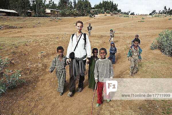 Junge Trekkerin beim Wandern mit einheimischen Kindern in den Simien-Bergen; Äthiopien