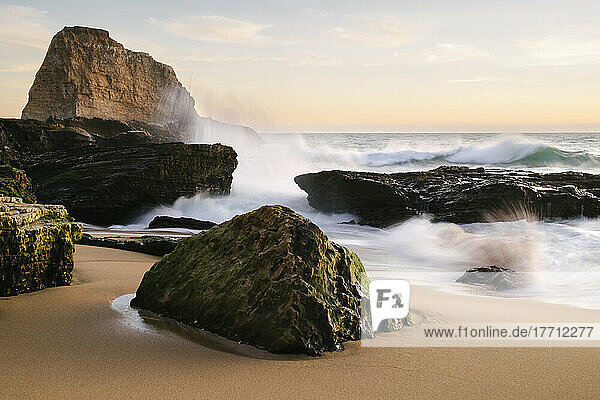 Sonnenuntergang an der kalifornischen Küste mit Wellen  die auf die großen Felsen am Strand prallen; Santa Cruz  Kalifornien  Vereinigte Staaten von Amerika