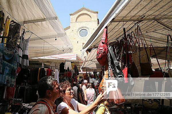 Einkaufen auf dem lokalen Markt auf dem Platz von San Gimignano  einer berühmten mittelalterlichen Stadt auf einem Hügel in der Toskana. Italien. Juni.