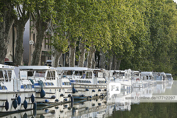 Boats Moored Along The Shoreline Of The Canal Du Midi; France
