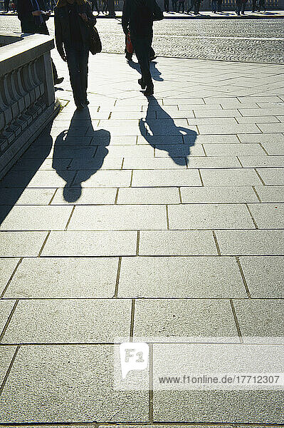 Fußgänger und ihr Schattenwurf auf einem Gehweg im Marais-Viertel; Paris  Frankreich