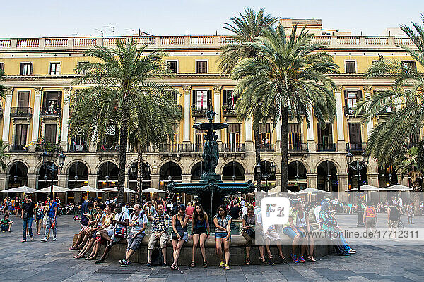 Menschen  die am Rand eines Wasserbrunnens auf der Plaza Real sitzen; Barcelona  Katalonien  Spanien