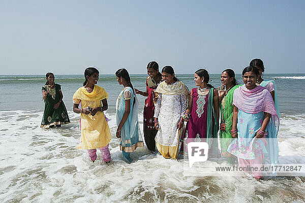 Frauen in ihren Saris  die in der Brandung am Rande des Wassers stehen; Gokarna  Karnataka  Indien