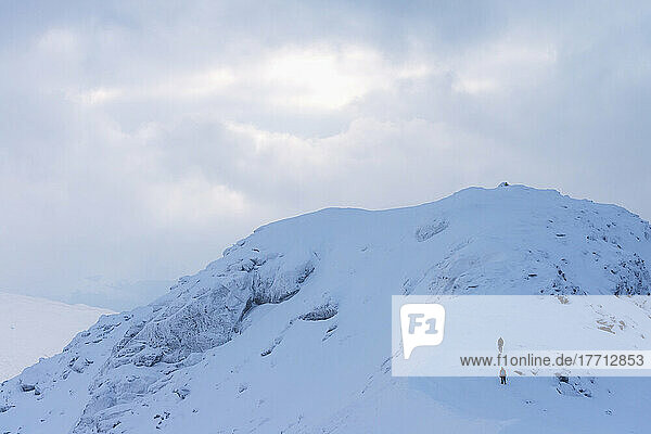 Zwei Menschen nähern sich dem Gipfel des Beinn Dorain bei verschneiten  winterlichen Bedingungen in der Nähe der Bridge of Orchy; Argyll und Bute  Schottland