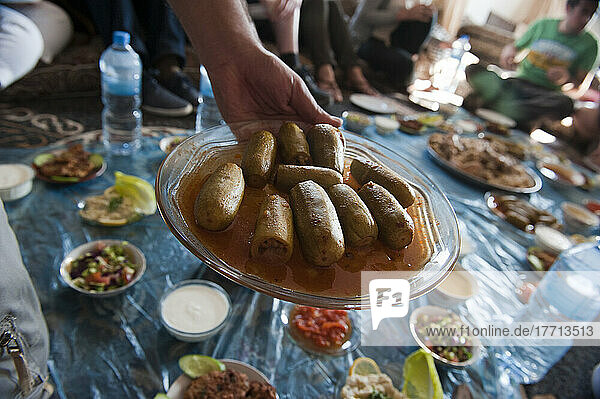 Eine Gruppe von Touristen  die ein traditionelles Mittagessen mit einer einheimischen Familie in der Nähe von Al Ayoun Trail; Jordanien