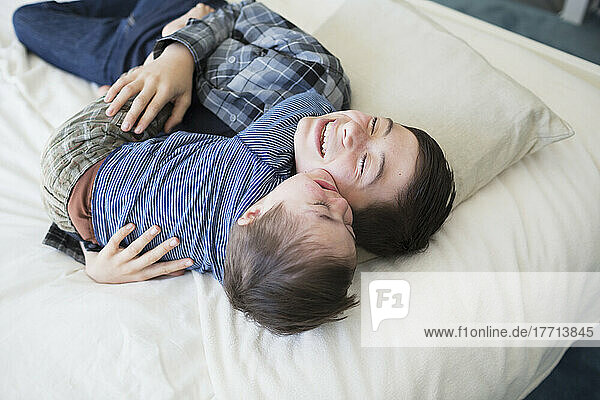 Brüder  die zu Hause auf einem großen Bett spielen  ein Junge hat das Down-Syndrom; Victoria  British Columbia  Kanada