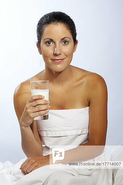 Frau eingewickelt in Blatt hält Glas Milch