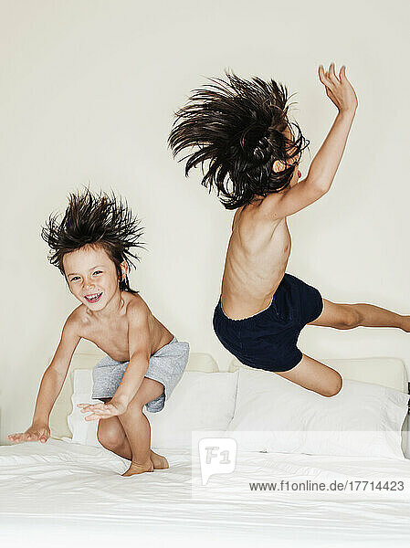 5 und 7 Jahre alte gemischtrassige Jungen  die auf einem Bett springen; Montreal  Quebec  Kanada